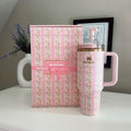Pink floral-patterned mug with matching box on a white surface